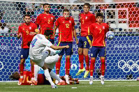 Khusniddin Alikulov takes a free kick against Spain